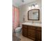 Neutral bathroom with a single sink vanity, decorative mirror and shower with peach curtain at 816 College Chase Dr, Ruskin, FL 33570