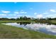 Enjoy serene pond views from this property, featuring lush landscaping and tranquil waters under blue skies at 816 College Chase Dr, Ruskin, FL 33570
