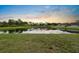 Enjoy serene pond views from this property, featuring lush landscaping and tranquil waters at sunset at 816 College Chase Dr, Ruskin, FL 33570
