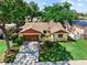 An aerial perspective displays a home with a well-kept lawn, driveway, and attached garage at 8315 W Elm St, Tampa, FL 33615