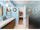 Contemporary bathroom featuring double sink vanity, an adjacent shower, wood-framed mirrors and blue painted walls at 8315 W Elm St, Tampa, FL 33615
