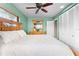 Relaxing bedroom with wooden bed frame, wooden dresser, a ceiling fan and white closet doors at 8315 W Elm St, Tampa, FL 33615