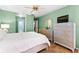 Relaxing bedroom showcasing tile floors, a ceiling fan, and a modern dresser with a decorative mirror at 8315 W Elm St, Tampa, FL 33615