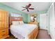 Cozy bedroom with a wooden bed frame, ceiling fan, and green accent wall at 8315 W Elm St, Tampa, FL 33615