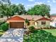 Charming single-story home with a well-manicured lawn and a spacious driveway leading to an attached two-car garage at 8315 W Elm St, Tampa, FL 33615