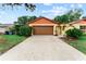 A well-maintained home showcasing a spacious driveway and an attached garage for convenient parking at 8315 W Elm St, Tampa, FL 33615