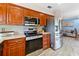 Updated kitchen with stainless steel appliances, wood cabinets, and an adjacent living room at 8315 W Elm St, Tampa, FL 33615