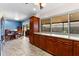 Bright kitchen with wood cabinets, tile floors, a blue accent wall, and an adjacent dining area at 8315 W Elm St, Tampa, FL 33615