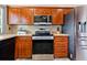 Kitchen featuring stainless steel appliances, wood cabinetry, and light countertops at 8315 W Elm St, Tampa, FL 33615