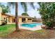 Serene backyard oasis featuring a private pool, covered patio, and well-maintained lawn for peaceful enjoyment at 8315 W Elm St, Tampa, FL 33615