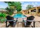 Beautiful backyard pool with patio seating, lush landscaping, and mature trees at 8315 W Elm St, Tampa, FL 33615