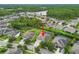 Aerial view showcasing a property with a screened pool and lake view, surrounded by lush greenery and neighboring homes at 8413 Swiss Chard Cir, Land O Lakes, FL 34637