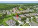 Aerial view showcasing a property with a screened pool and lake view, surrounded by lush greenery and neighboring homes at 8413 Swiss Chard Cir, Land O Lakes, FL 34637