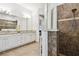 Bright bathroom featuring a tiled walk-in shower and double sink vanity at 8413 Swiss Chard Cir, Land O Lakes, FL 34637