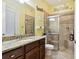Well-lit bathroom with a granite countertop vanity and a tiled glass-enclosed shower at 8413 Swiss Chard Cir, Land O Lakes, FL 34637
