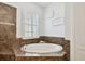 Close-up of a bathroom with a garden tub and decorative tile at 8413 Swiss Chard Cir, Land O Lakes, FL 34637