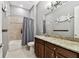 Bathroom with dark wood vanity, granite countertop, and tiled tub/shower at 8413 Swiss Chard Cir, Land O Lakes, FL 34637