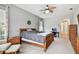 Well-lit bedroom with ceiling fan, light gray walls, and wood furniture at 8413 Swiss Chard Cir, Land O Lakes, FL 34637