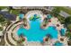 Aerial view of a large community pool and splashpad surrounded by palm trees and seating at 8413 Swiss Chard Cir, Land O Lakes, FL 34637
