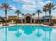 A gorgeous community pool with palm trees and a clubhouse in the background at 8413 Swiss Chard Cir, Land O Lakes, FL 34637