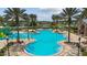 Aerial view of resort-style community pool featuring zero entry and splash pad amidst palm trees and lounge areas at 8413 Swiss Chard Cir, Land O Lakes, FL 34637