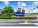 A vibrant blue 'Connerton' sign at the entrance, surrounded by lush greenery under a bright sky at 8413 Swiss Chard Cir, Land O Lakes, FL 34637