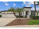 Attractive single-story home featuring an attached three-car garage and beautifully designed landscaping at 8413 Swiss Chard Cir, Land O Lakes, FL 34637