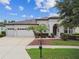 Charming single-story home featuring a three-car garage and well-manicured landscaping with palm trees at 8413 Swiss Chard Cir, Land O Lakes, FL 34637