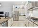 Bright kitchen with stainless steel appliances, granite countertops, and white cabinetry at 8413 Swiss Chard Cir, Land O Lakes, FL 34637