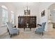 Charming living room with tile flooring, crown molding, display cabinet and bright windows at 8413 Swiss Chard Cir, Land O Lakes, FL 34637
