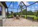 The spacious screened-in patio has outdoor seating, a firepit and leads to the backyard at 8413 Swiss Chard Cir, Land O Lakes, FL 34637