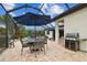 Relaxing screened patio features a dining set and grill, ideal for outdoor entertaining and enjoying the Florida weather at 8413 Swiss Chard Cir, Land O Lakes, FL 34637