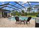 Inviting screened pool area with multiple seating options and lush landscaping, perfect for relaxation and entertaining at 8413 Swiss Chard Cir, Land O Lakes, FL 34637