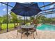 Inviting screened pool area with covered dining set, perfect for Gathering gatherings and poolside relaxation at 8413 Swiss Chard Cir, Land O Lakes, FL 34637