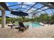 Relaxing screened pool area with lounge chairs, covered dining set, and lush landscaping for privacy at 8413 Swiss Chard Cir, Land O Lakes, FL 34637