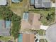 Aerial view of a private home featuring a backyard swimming pool surrounded by mature trees and a driveway at 8521 Caitlin Ct, Hudson, FL 34667