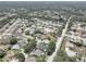 An aerial view of a quiet neighborhood with well-maintained homes, tree-lined streets, and community pools at 8521 Caitlin Ct, Hudson, FL 34667