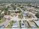 An aerial view of a quiet neighborhood with well-maintained homes, tree-lined streets, and community pools at 8521 Caitlin Ct, Hudson, FL 34667