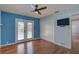 Bedroom with hardwood floors, ceiling fan, TV, closet, and door to outdoor pool at 8521 Caitlin Ct, Hudson, FL 34667