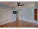 Spacious bedroom featuring hardwood floors, TV, ceiling fan, and natural light at 8521 Caitlin Ct, Hudson, FL 34667