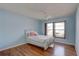 This cozy bedroom is decorated in blue with a wicker headboard and wood floors at 8521 Caitlin Ct, Hudson, FL 34667
