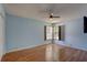 Bedroom with hardwood floors, a ceiling fan, and shuttered windows provides a cozy retreat at 8521 Caitlin Ct, Hudson, FL 34667