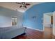 This bedroom features a bright blue accent wall, high ceilings and wood floors at 8521 Caitlin Ct, Hudson, FL 34667
