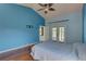 This spacious bedroom features a blue accent wall, vaulted ceiling, wood floors and access to the pool at 8521 Caitlin Ct, Hudson, FL 34667