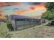 Back exterior view of a home with a large screened-in pool and spa area at 8521 Caitlin Ct, Hudson, FL 34667
