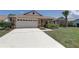 Well-maintained single-Gathering home with a two-car garage, brick accents, and green lawn at 8521 Caitlin Ct, Hudson, FL 34667