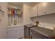 Well-lit laundry room with a sink, storage shelves, and modern washer and dryer units at 8521 Caitlin Ct, Hudson, FL 34667