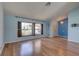 Bright and airy living room featuring hardwood floors, large windows and stylish light fixture at 8521 Caitlin Ct, Hudson, FL 34667