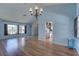 Spacious living room featuring hardwood floors, large windows, and stylish chandelier at 8521 Caitlin Ct, Hudson, FL 34667