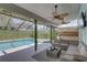 Outdoor living area featuring a seating area and outdoor kitchen with a view of the pool and spa at 8521 Caitlin Ct, Hudson, FL 34667